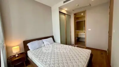 Modern bedroom with wooden flooring and built-in wardrobe in a stylish apartment.