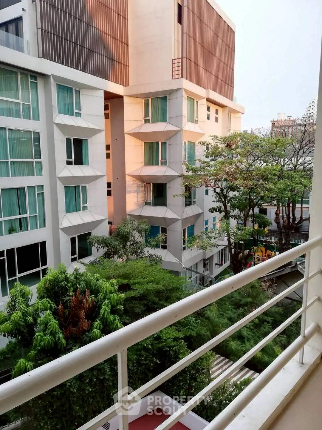 Modern apartment building with lush greenery and spacious balconies, offering a serene urban living experience.