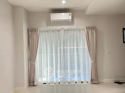 Bright living room with air conditioning and elegant curtains, perfect for comfortable living.