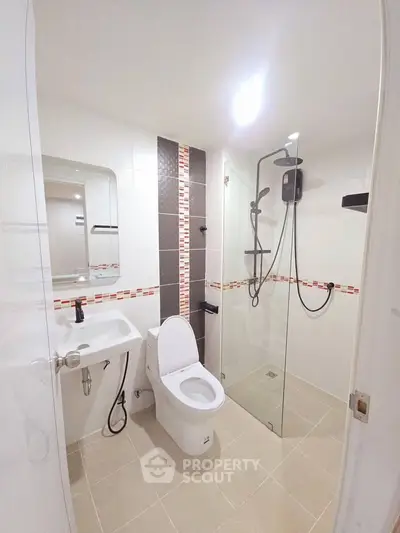 Modern bathroom with glass shower and sleek fixtures in contemporary home.