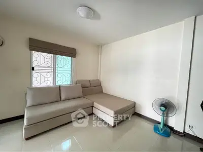 Cozy living room with modern sofa and fan, perfect for relaxation.