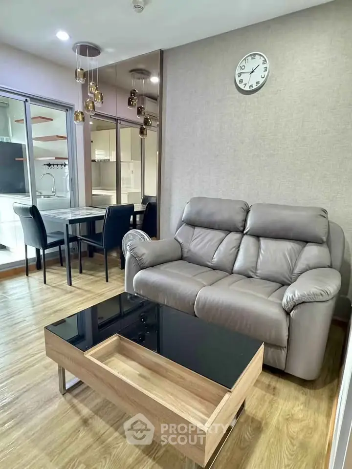 Modern living room with cozy leather sofa and elegant dining area in open layout apartment.