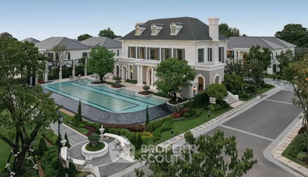 Luxurious mansion with grand pool and elegant landscaping in upscale neighborhood.