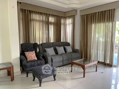 Elegant living room with plush seating and natural light through large windows.
