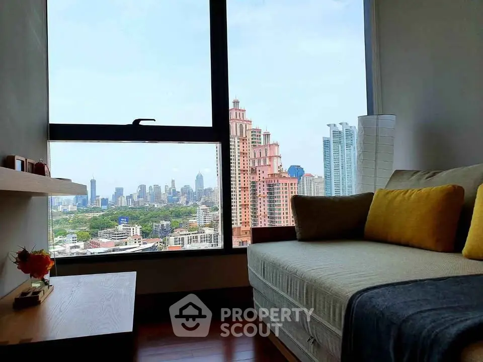 Stunning city view from modern living room with cozy seating and large window.