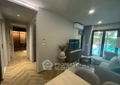 Modern living room with pool view, stylish decor, and natural light