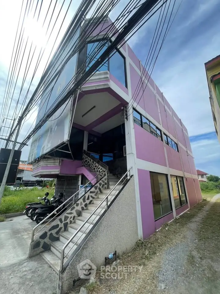 Vibrant purple commercial building with modern architecture and large windows, ideal for business opportunities.