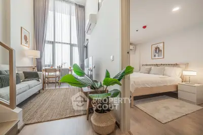 Modern open-plan living room and bedroom with stylish decor and natural light