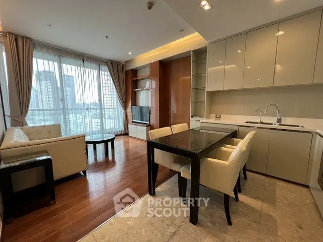 Modern open-layout living room and kitchen with city view, elegant furnishings, and natural light.