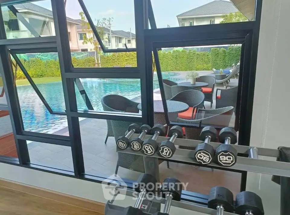 Luxurious gym with pool view in modern residential complex