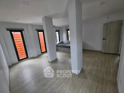Spacious modern living room with large windows and sleek wooden flooring