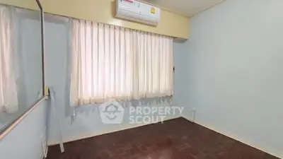 Spacious empty bedroom with air conditioning and large window