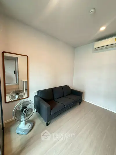 Cozy living room with modern sofa and air conditioning in a minimalist apartment.