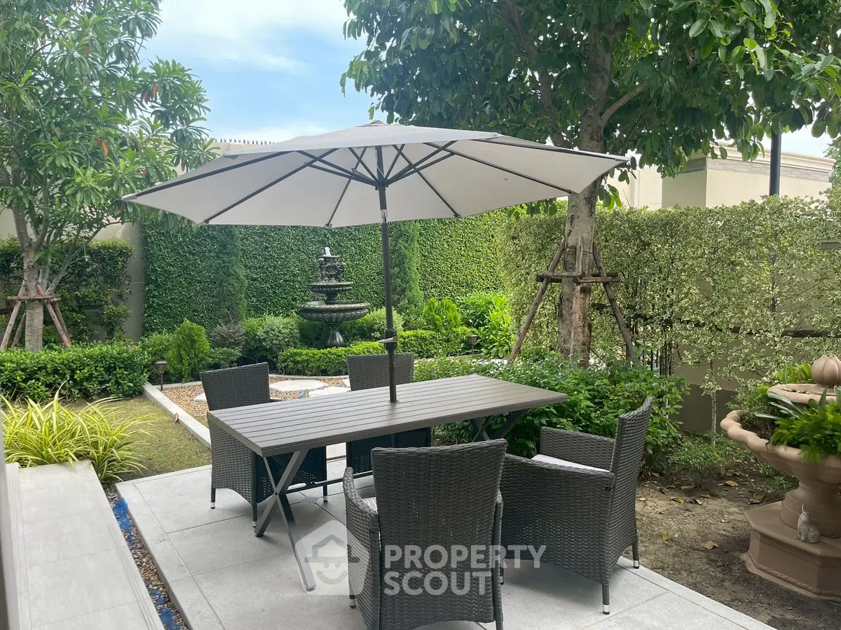 Charming garden patio with elegant outdoor furniture and lush greenery, perfect for relaxation and entertaining.