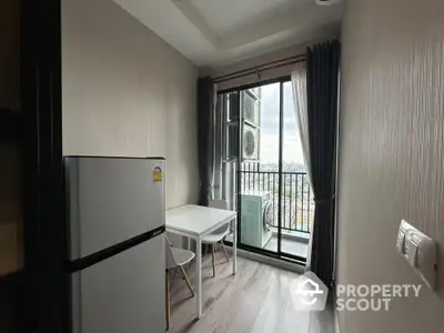 Compact kitchen dining area with balcony view and modern appliances