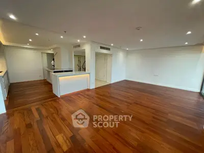 Spacious modern living room with hardwood floors and recessed lighting
