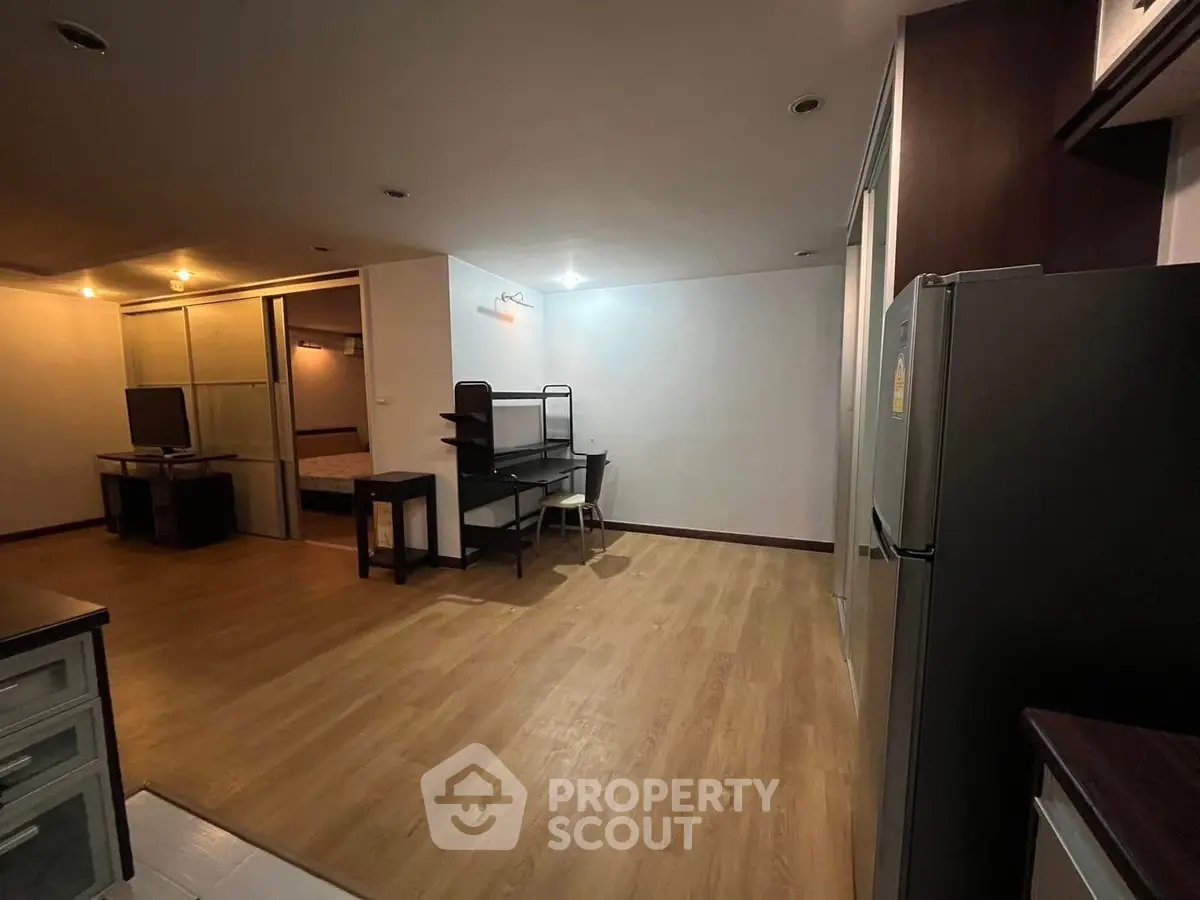 Spacious open-plan living area with modern furnishings and wooden flooring.