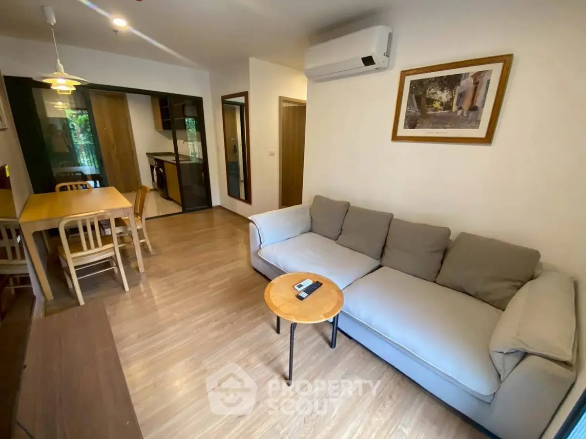 Modern living room with cozy sofa and dining area in open layout apartment.