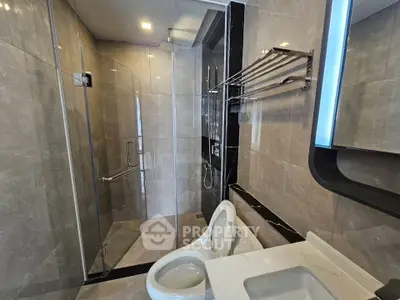 Modern bathroom with glass shower and sleek fixtures in luxury apartment