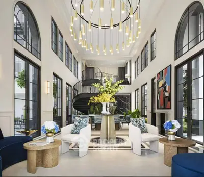 Luxurious living room with high ceilings, elegant chandelier, and spiral staircase in modern home.