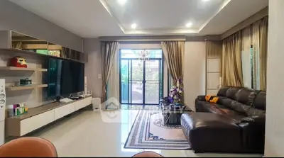 Spacious living room with modern decor and large TV, perfect for relaxation.