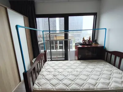 Spacious bedroom with large windows and city view, featuring a comfortable bed and modern decor.