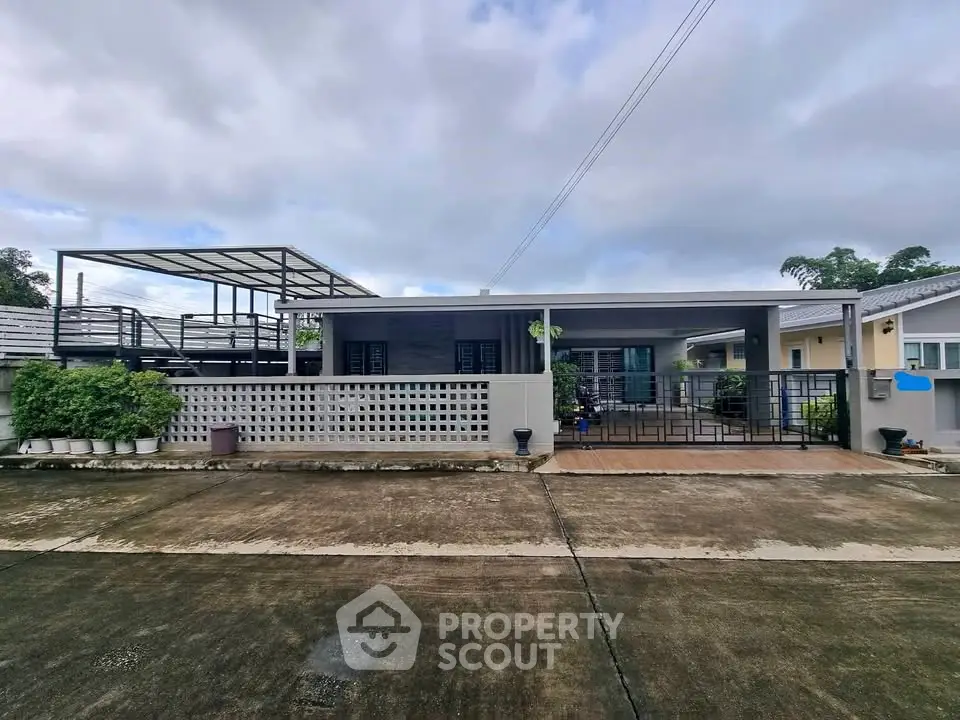 Modern single-story house with spacious driveway and rooftop terrace.