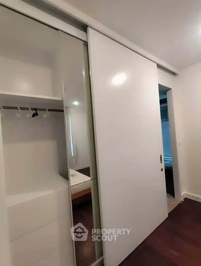 Modern bedroom with sleek sliding closet doors and minimalist design.