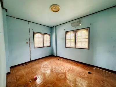 Spacious empty room with tiled floor and two large windows, ideal for customization.