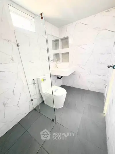 Modern bathroom with glass shower and sleek white fixtures