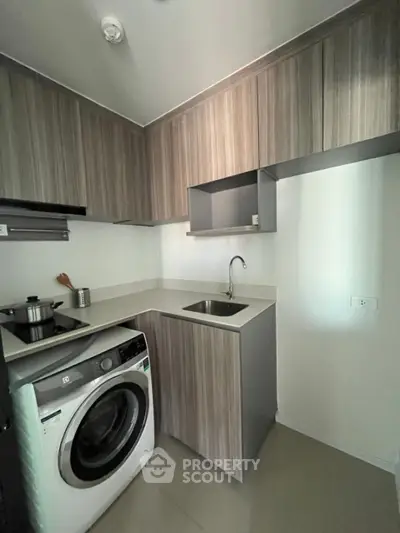 Modern compact kitchen with washing machine and sleek cabinetry