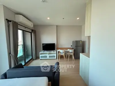 Modern living room with balcony, TV, and dining area in open layout apartment.