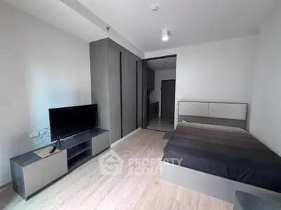 Modern studio apartment with sleek design and integrated kitchen area, perfect for urban living.