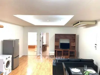 Spacious living room with modern appliances and sleek wooden flooring