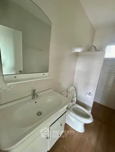 Modern bathroom with sleek white fixtures and elegant tile design.