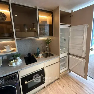 Modern kitchen with built-in appliances and open fridge showcasing sleek design.