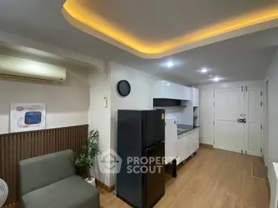 Modern kitchen with sleek appliances and stylish lighting in a cozy apartment.