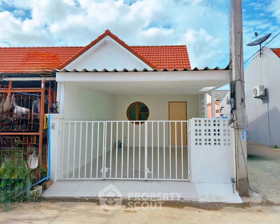Charming single-story house with red roof and gated front yard, perfect for cozy living.