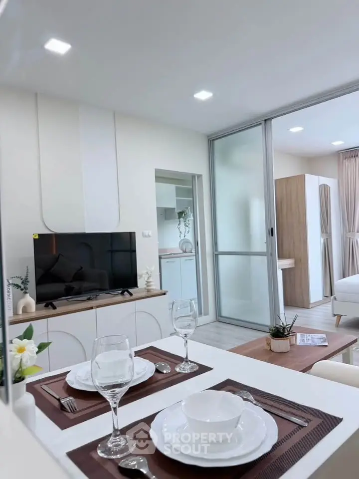 Modern open-plan living room with dining area, featuring sleek furniture and a cozy ambiance.