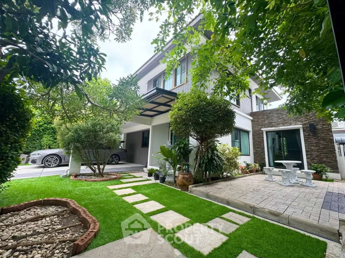 Charming two-story house with lush garden and modern driveway, perfect for family living.
