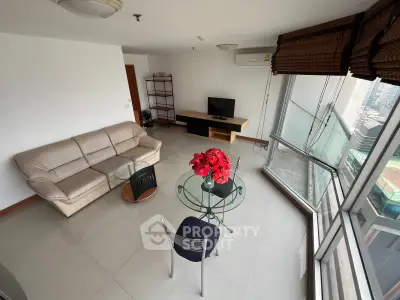 Spacious living room with city view, modern furniture, and large windows for natural light.