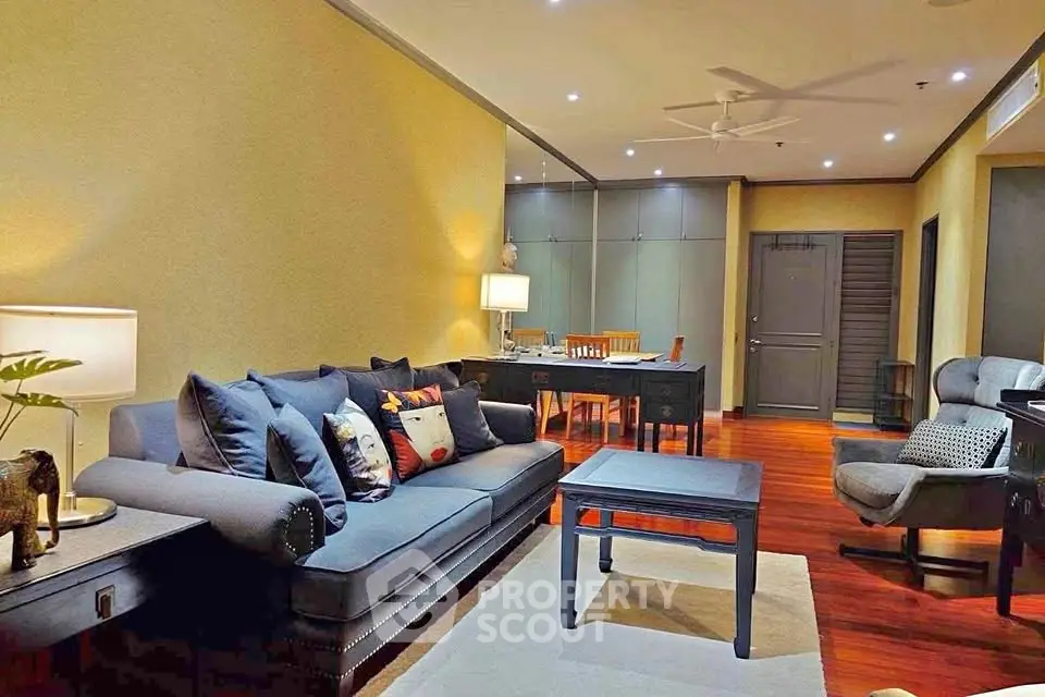 Spacious living room with elegant furniture and warm lighting, perfect for relaxation and entertainment.
