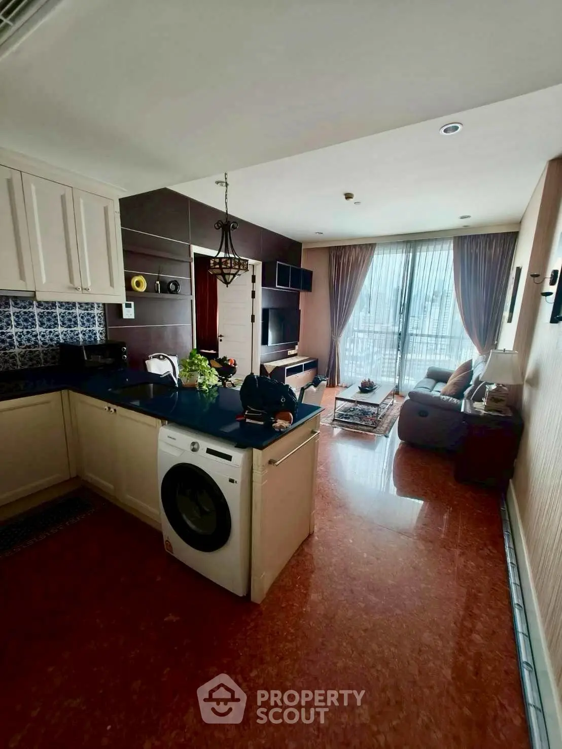 Spacious open-plan living room with modern kitchen and balcony access