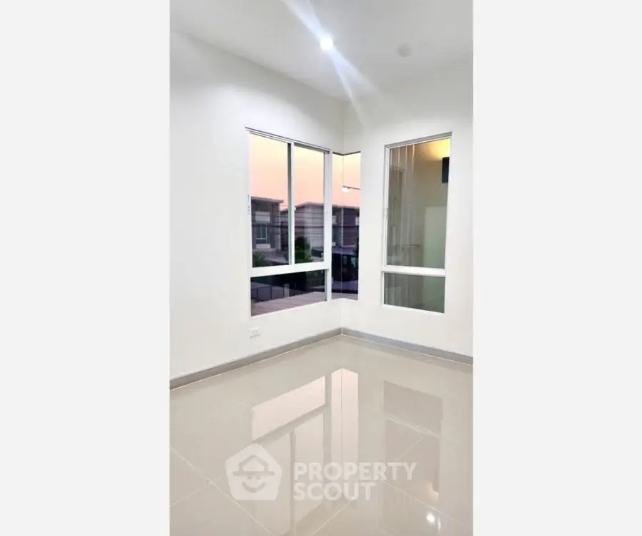 Bright empty room with large windows and glossy tiled floor, perfect for customization.