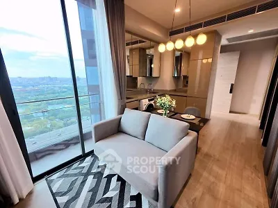 Modern living room with open kitchen and stunning city view from balcony.