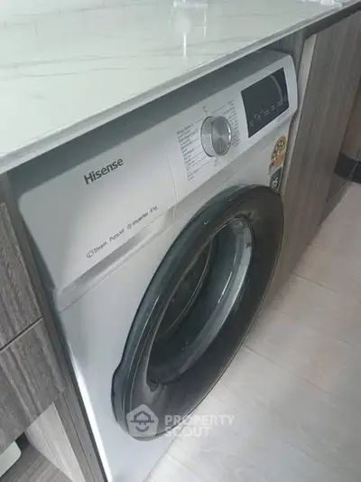 Modern kitchen with built-in Hisense washing machine and sleek cabinetry.
