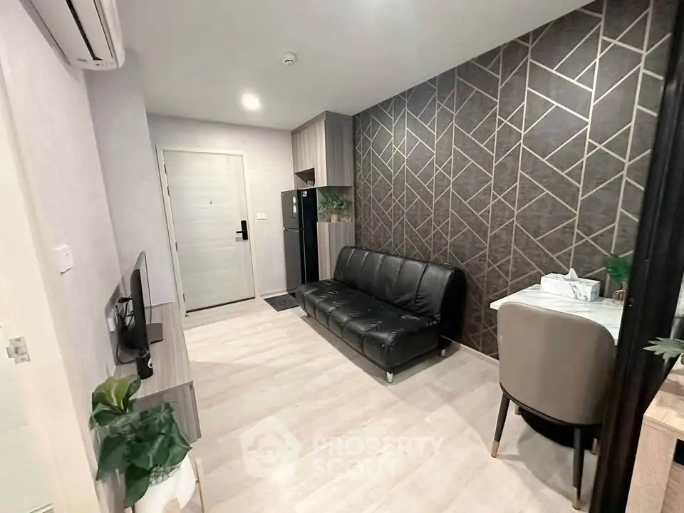 Modern living room with stylish geometric accent wall and sleek black sofa