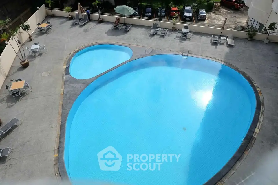 Spacious outdoor swimming pool area with sun loungers and tables, perfect for relaxation and leisure.
