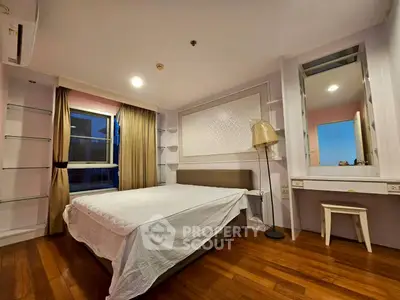 Spacious bedroom with modern decor and large window for natural light.