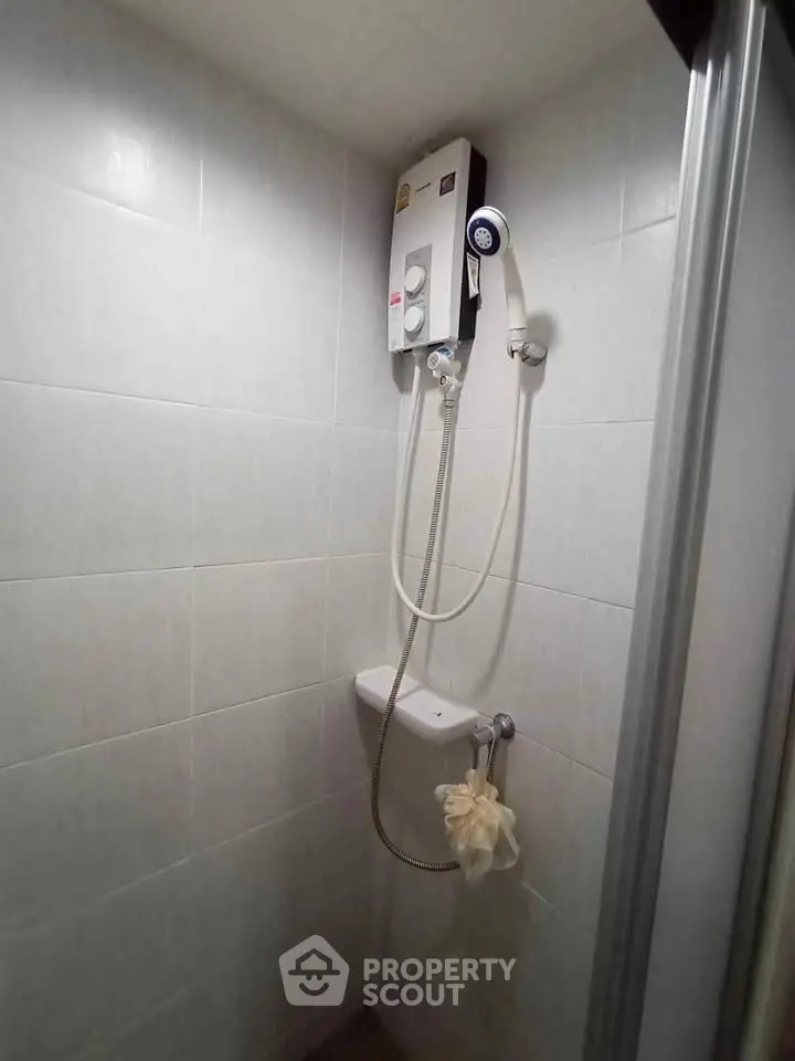 Compact bathroom shower area with wall-mounted water heater